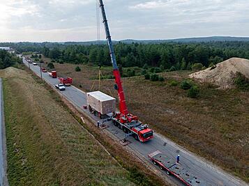 Crane lifting a large box off a stand